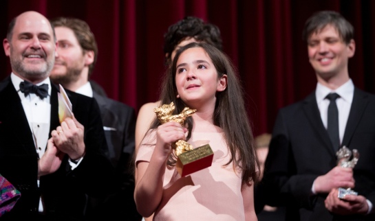 epa04620090 Hana Saeidi (C) holds the Golden Bear for the movie 'Taxi', which she accepted on behalf of Iranian director Jafar Panahi, during the closing and award ceremony of the 65th annual Berlin International Film Festival, in Berlin, Germany, 14 February 2015. The Berlinale runs from 05 to 15 February. EPA/MICHAEL KAPPELER